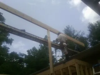 Carpenter setting a ridge beam over a new addition frame — Ice Dam Removal by Roofing Brothers in Brookdale