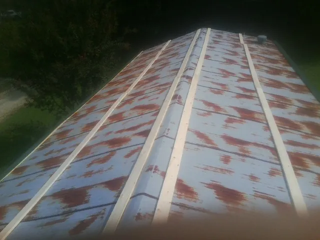 Rusted metal roof panels with new wood purlins before replacement — Storm Damage Roof Repair in Brookdale by Roofing Brothers